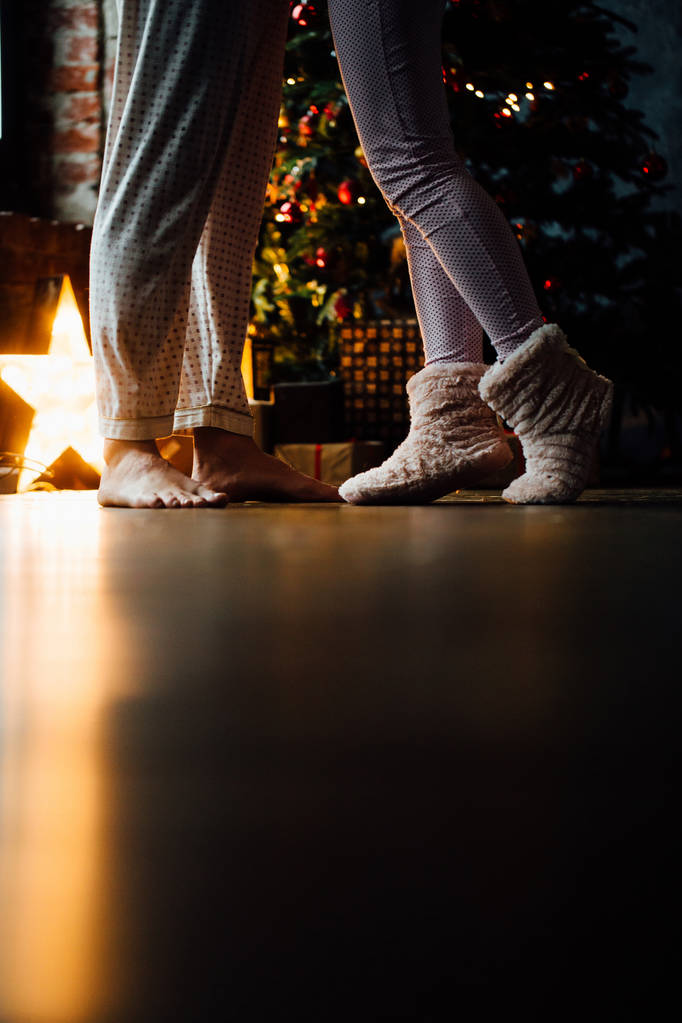 Beine des Paares auf Weihnachtsbaum Hintergrund - Foto, Bild