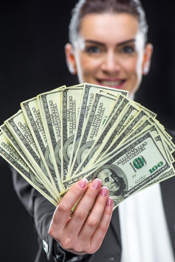 Empresaria sosteniendo billetes en dólares
 - Foto, imagen