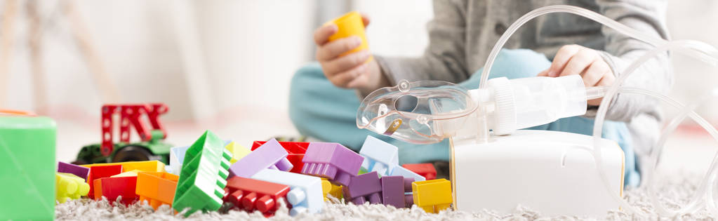 Criança com brinquedos e inalador de asma
 - Foto, Imagem