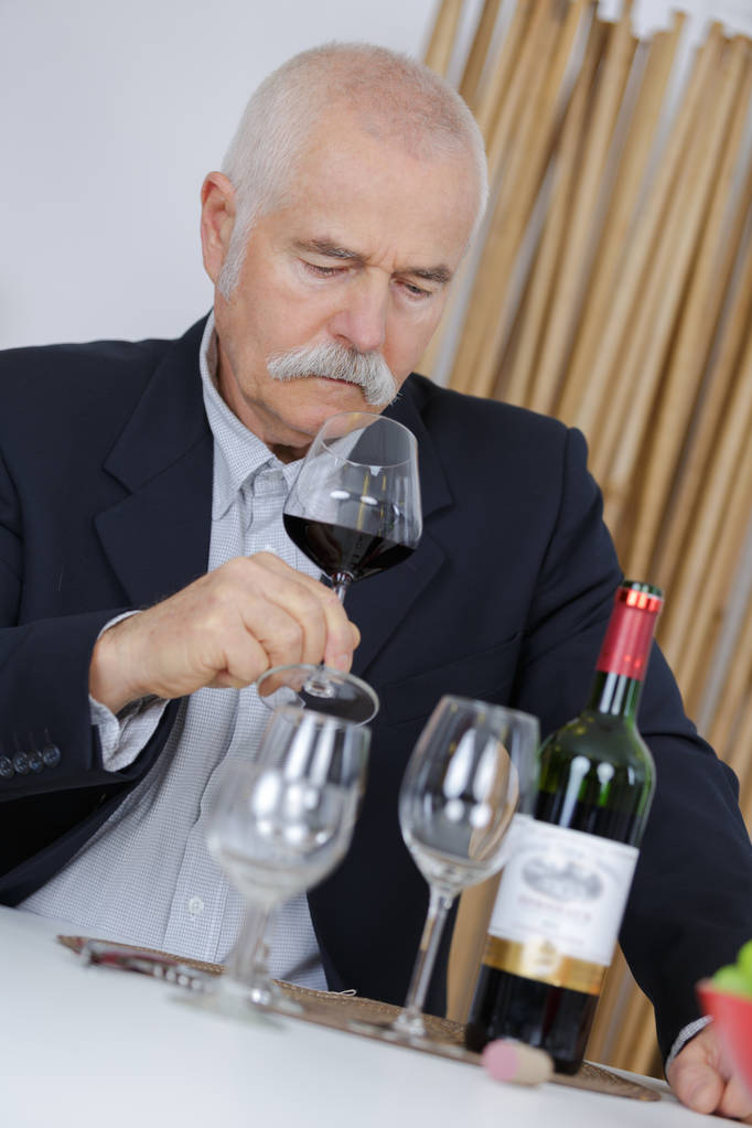 пожилой человек, нюхающий красное вино
 - Фото, изображение
