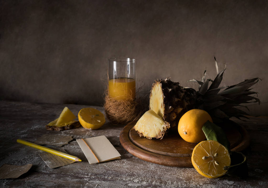 Natürmort. ananas, limon, tropikal meyve suyu, ahşap bir masa üzerinde eski gümüş bıçak - Fotoğraf, Görsel