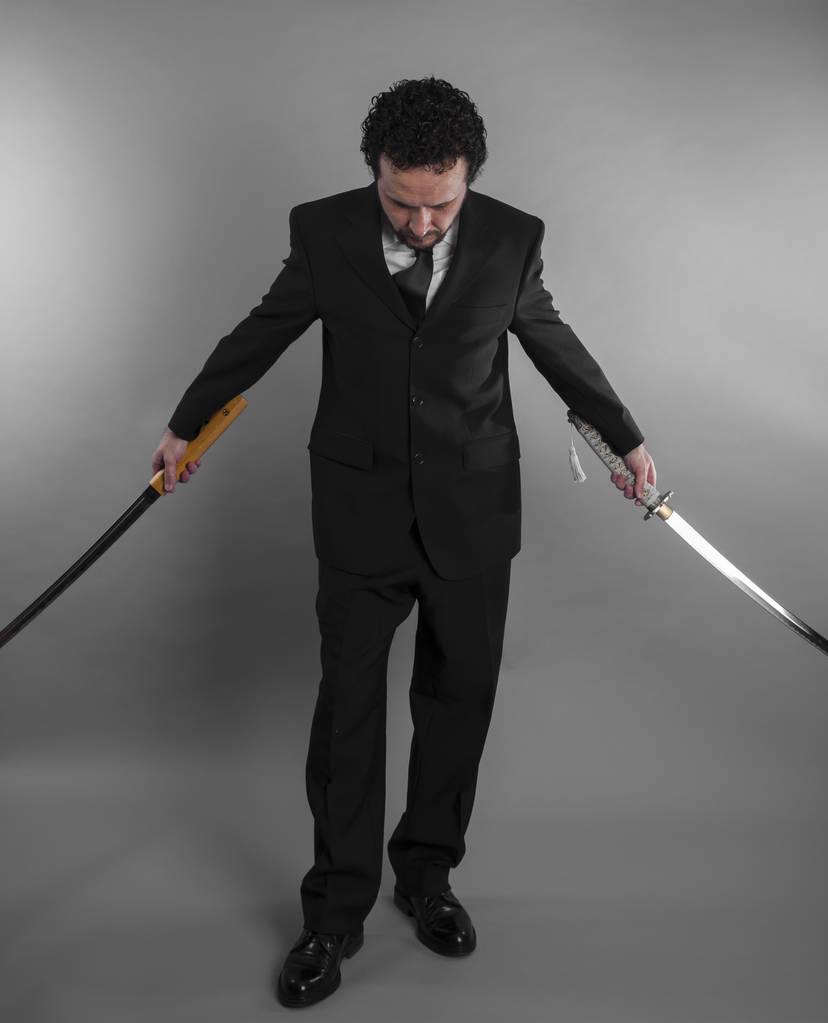 Empresário agressivo com espadas japonesas
 - Foto, Imagem