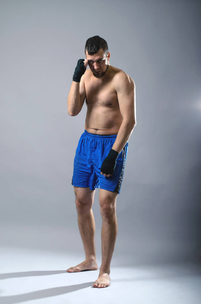 Portrait de kickboxer sur fond gris
. - Photo, image