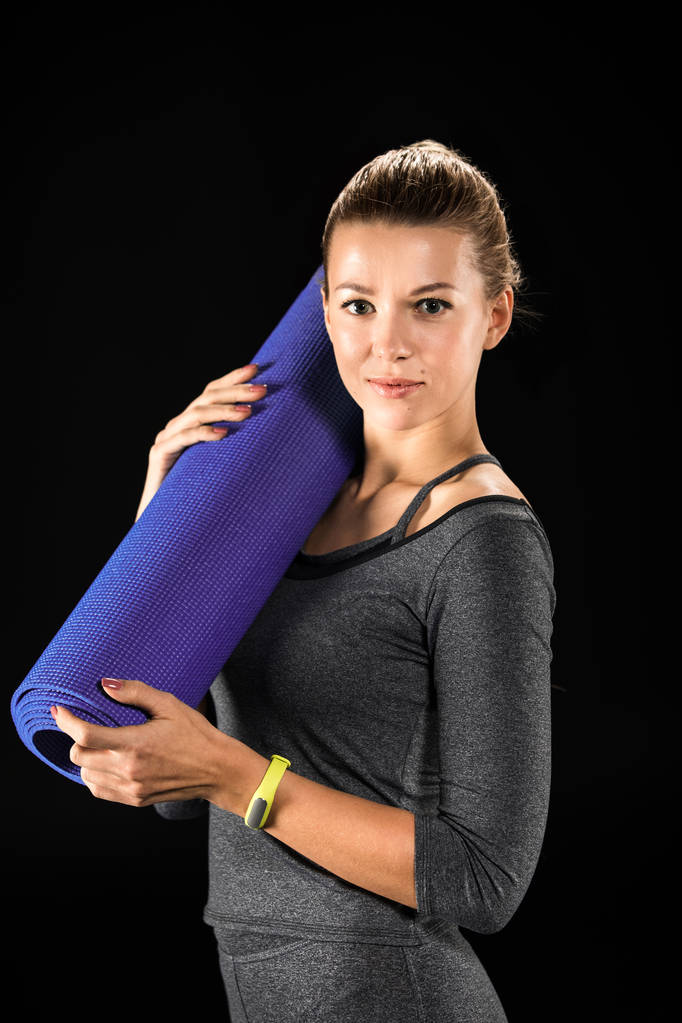 Спортсменка держит коврик для йоги
  - Фото, изображение