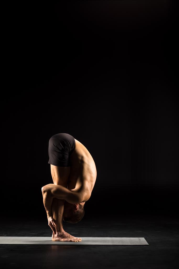 Homem em pé na posição de ioga
 - Foto, Imagem