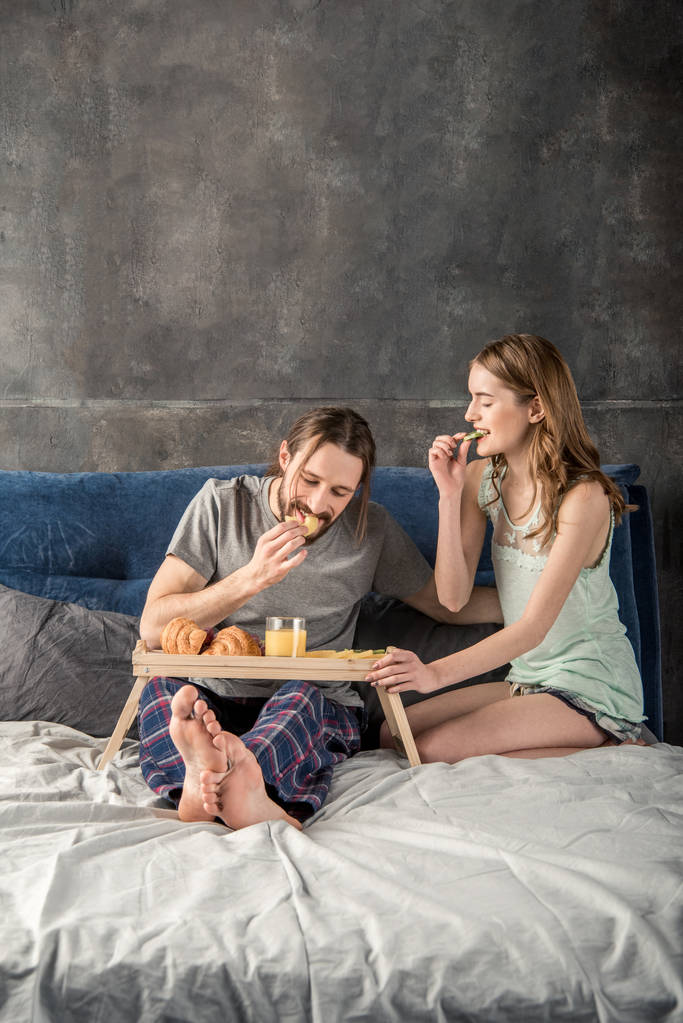 Pariskunta on aamiainen sängyssä
 - Valokuva, kuva