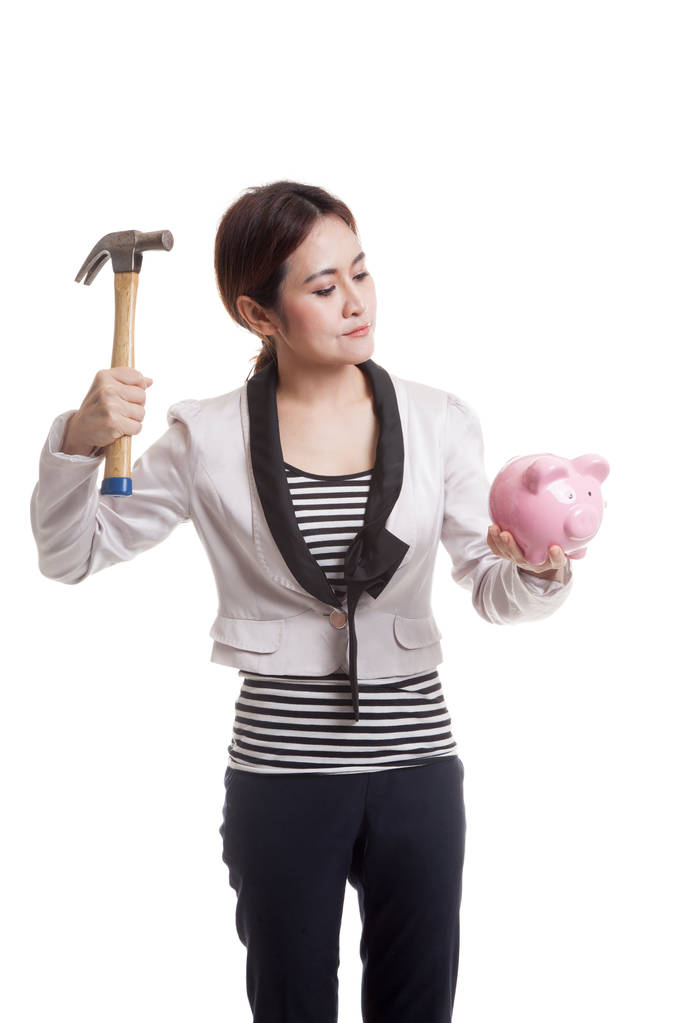 Aziatische zakenvrouw met varken munt bank en hammer. - Foto, afbeelding