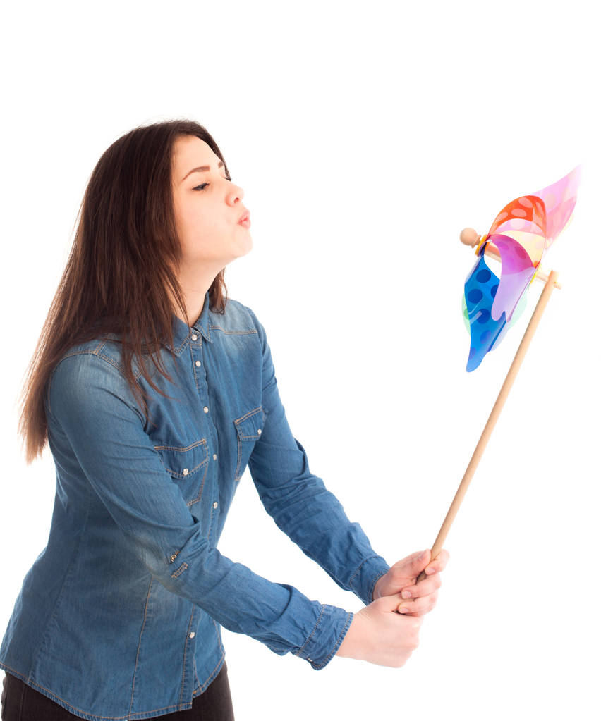 Красива дівчина грає з кольоровим вітряком ізольовані
 - Фото, зображення