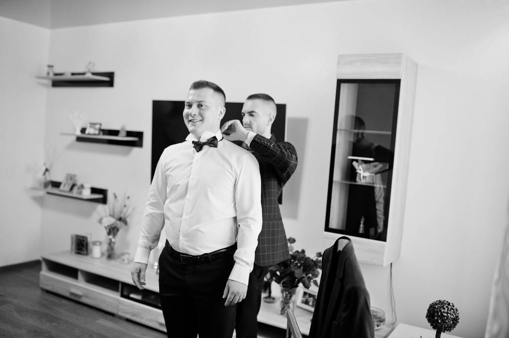 Best man helping wear groom on his wedding day. Black and white  - Photo, Image