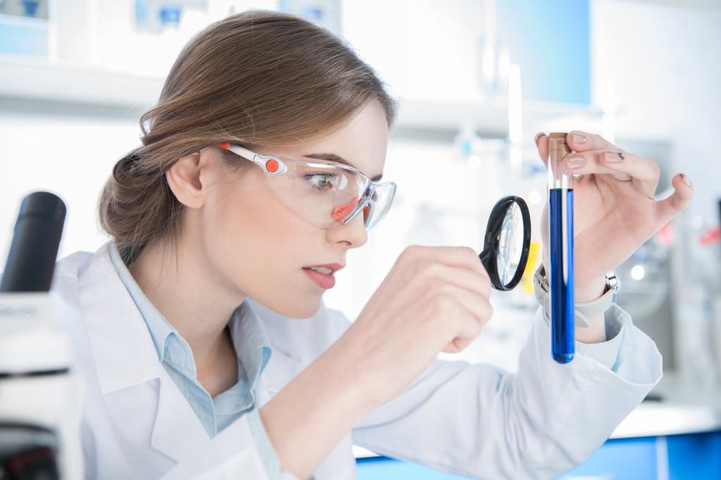 Scientist looking on test tube - Photo, Image