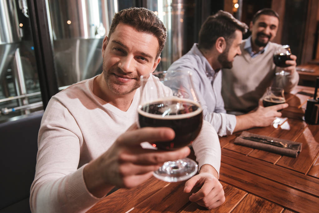 Красивий позитивний чоловік п'є пиво
 - Фото, зображення