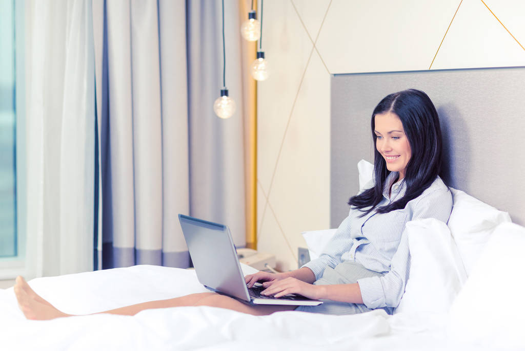 otel odasında dizüstü bilgisayar ile mutlu iş kadını - Fotoğraf, Görsel