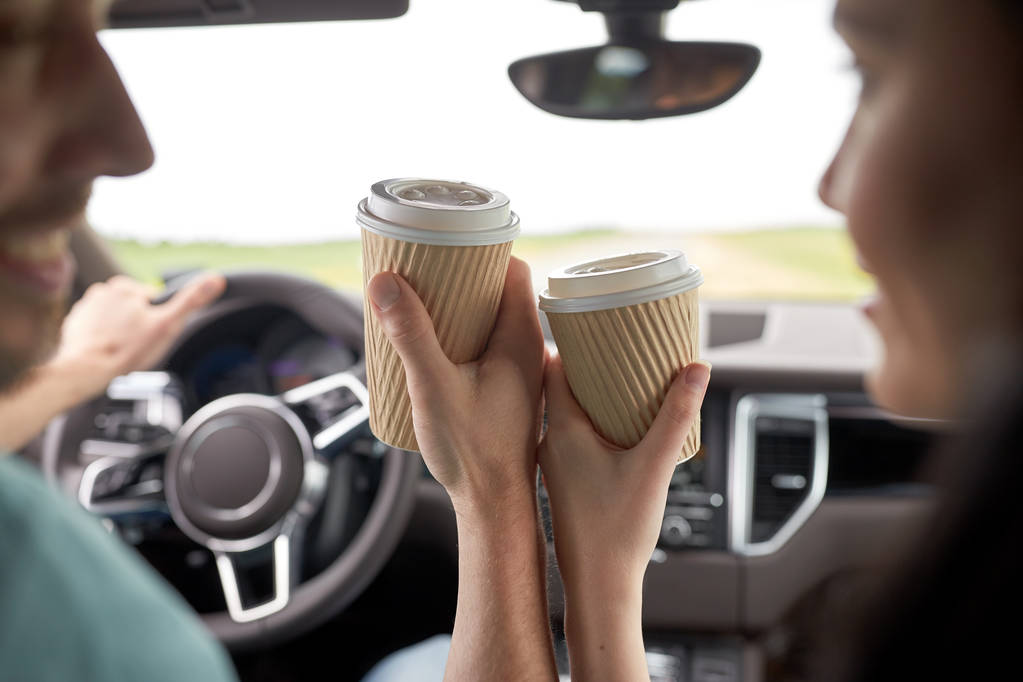 primo piano di coppia guida in auto con tazze di caffè
 - Foto, immagini