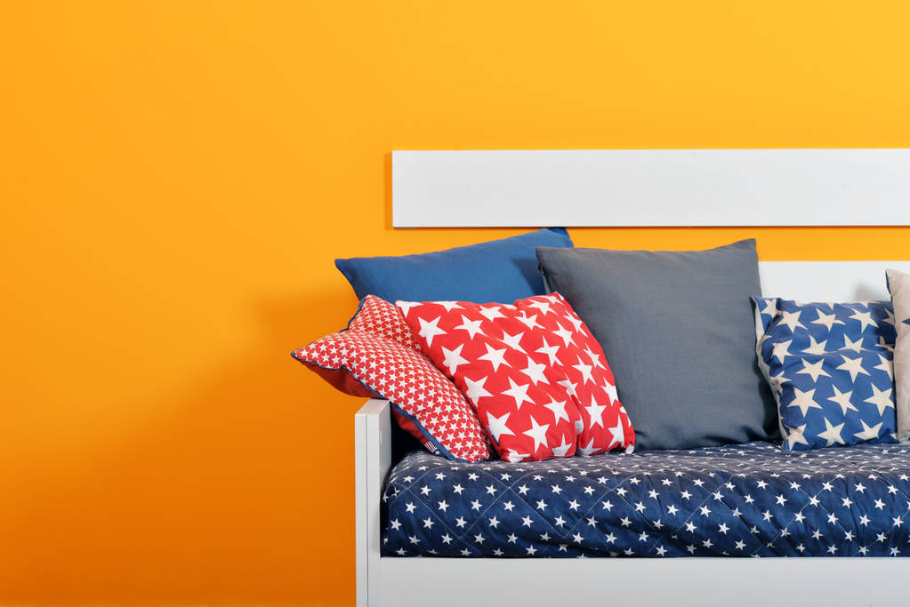 Cama para niños con almohadas de diferentes colores
 - Foto, imagen