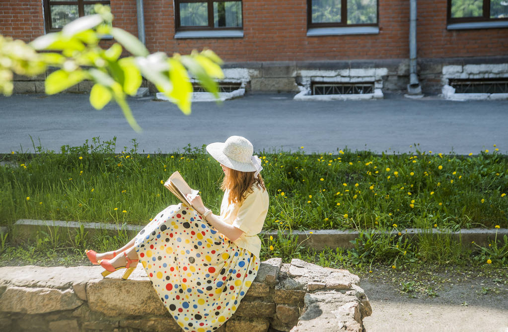 beautiful girl in yellow dress with book - Photo, Image