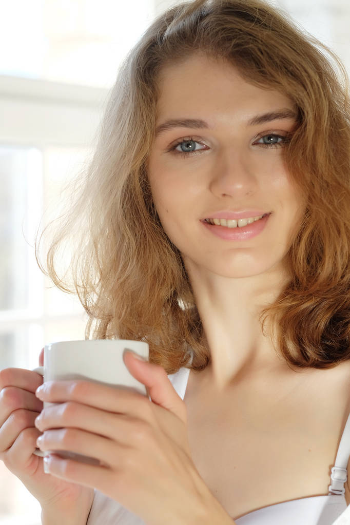 Mooie vrouw dragen witte lingerie koffie drinken in de mo - Foto, afbeelding