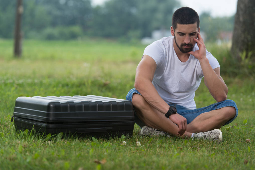 Homme frustré assis sur l'herbe avec cas Drone
 - Photo, image