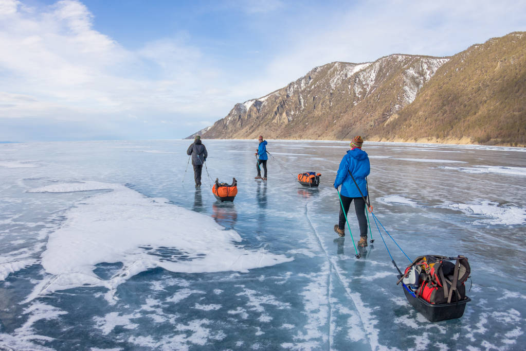 Frau und Mann mit Schlitten und Trekkingstock sind Eis vom Baikalsee - Foto, Bild