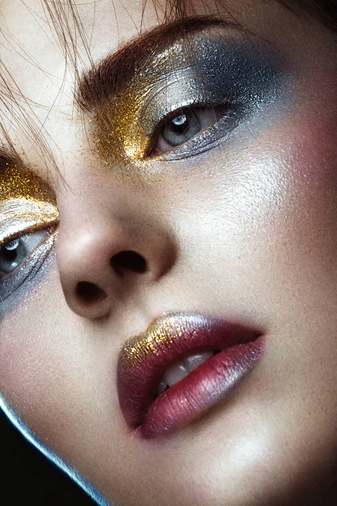 Beautiful girl with creative golden and silver glitter make-up. beauty face. - Photo, Image