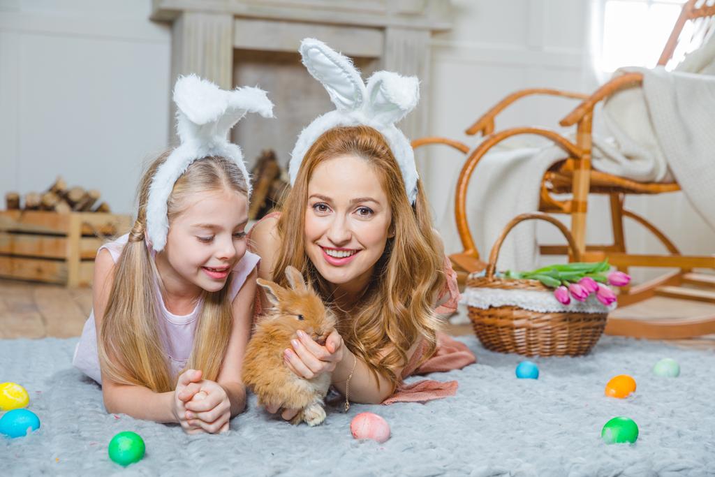 Mother and daughter playing with rabbit - Photo, Image