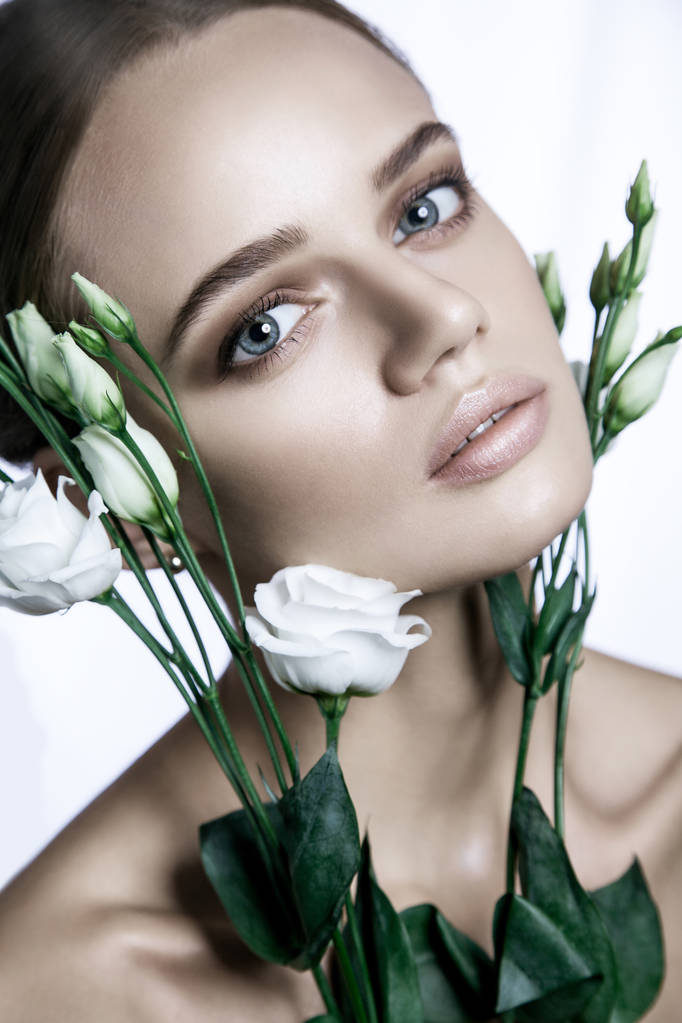 Модель спокійної краси Жінка обличчя. Портрет з білою квіткою троянд
.  - Фото, зображення