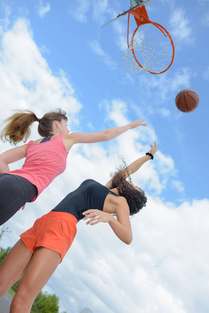 Ανοδική άποψη των δύο γυναίκες παίζουν μπάσκετ - Φωτογραφία, εικόνα