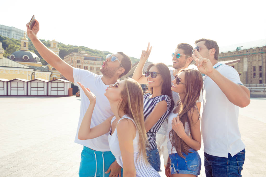 Garçons et filles heureux marchant dans la ville et faisant selfie drôle
 - Photo, image