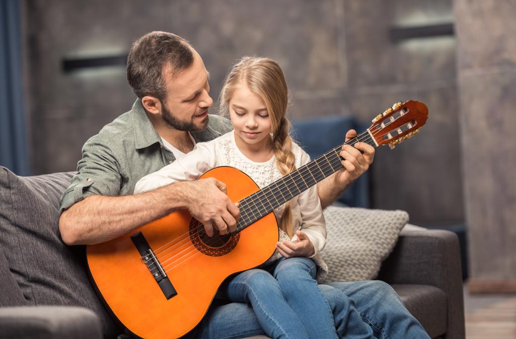 Vater und Tochter spielen Gitarre - Foto, Bild