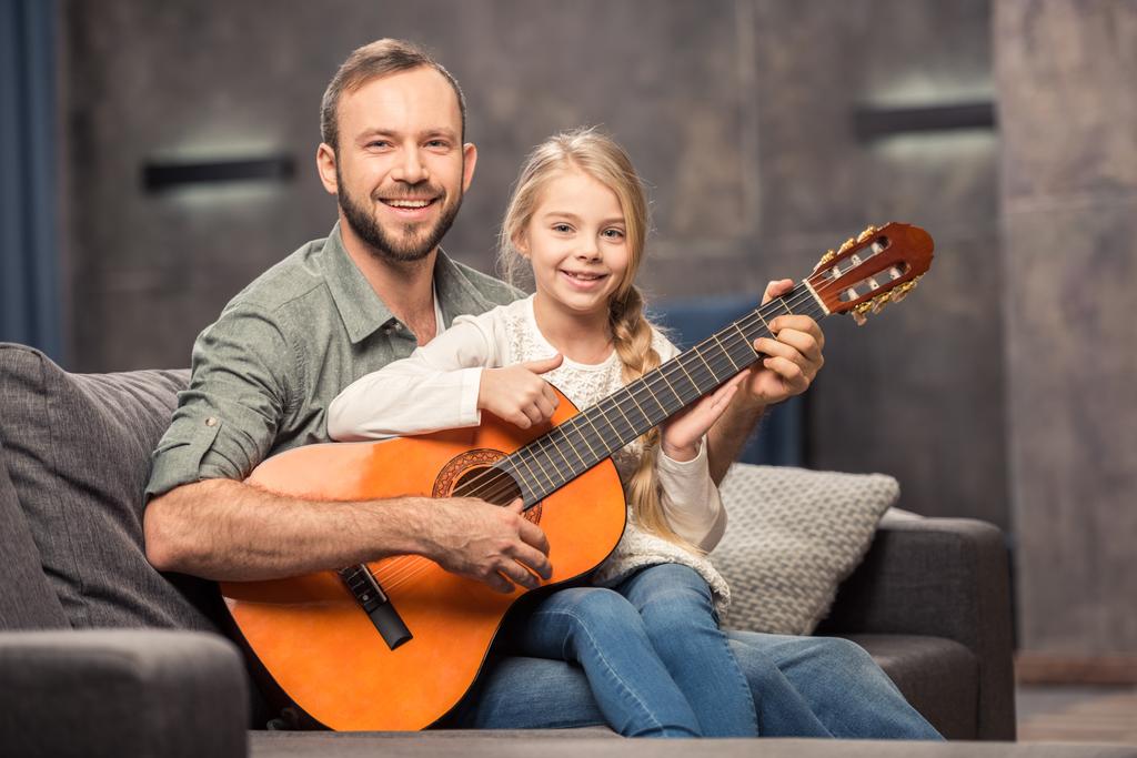 père et fille jouant de la guitare
 - Photo, image