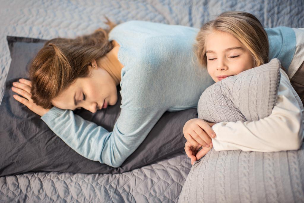 Madre e figlia sdraiate sul letto
 - Foto, immagini