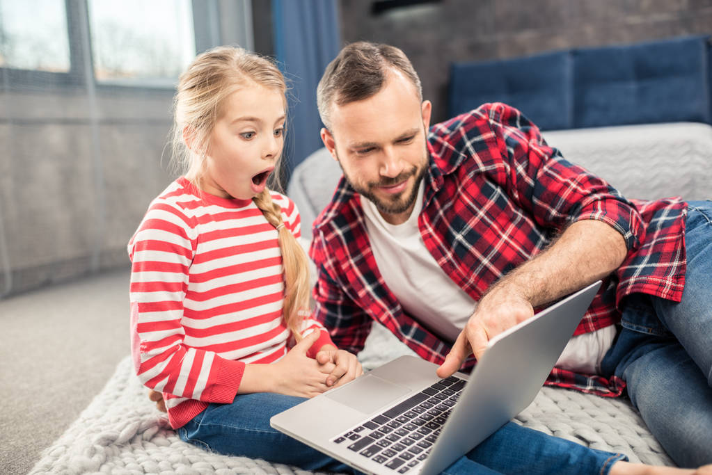 Отец и дочь используют ноутбук  - Фото, изображение