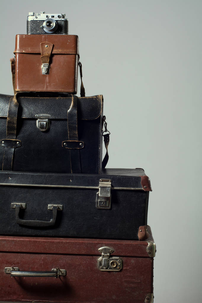 Пачка старых потрепанных чемоданов и фотоаппарат
 - Фото, изображение