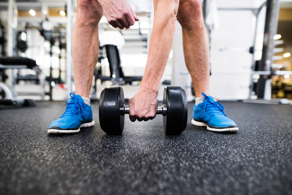 Hombre mayor irreconocible en el gimnasio haciendo ejercicio con pesas
 - Foto, Imagen
