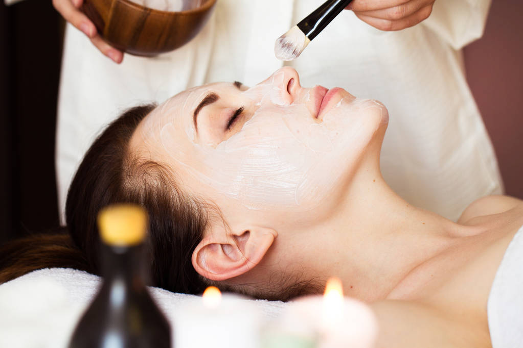 Spa treatment. Beautiful woman with facial mask at beauty salon. - Photo, Image