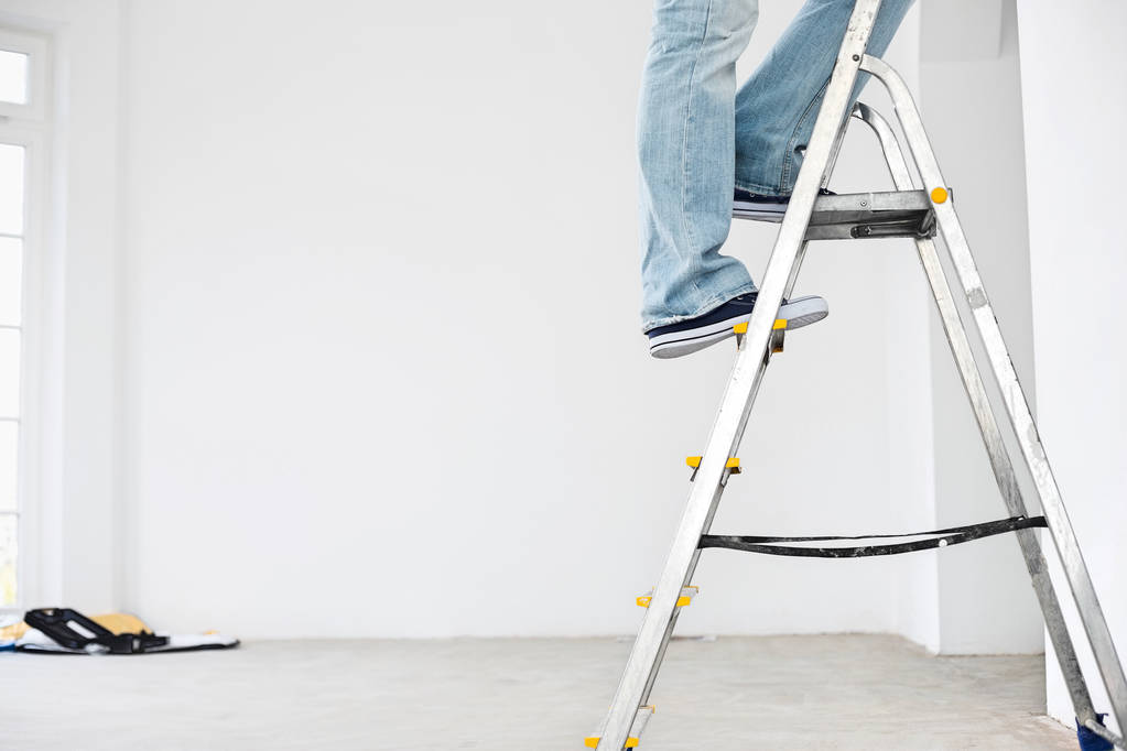 Man in spijkerbroek op ladder - Foto, afbeelding