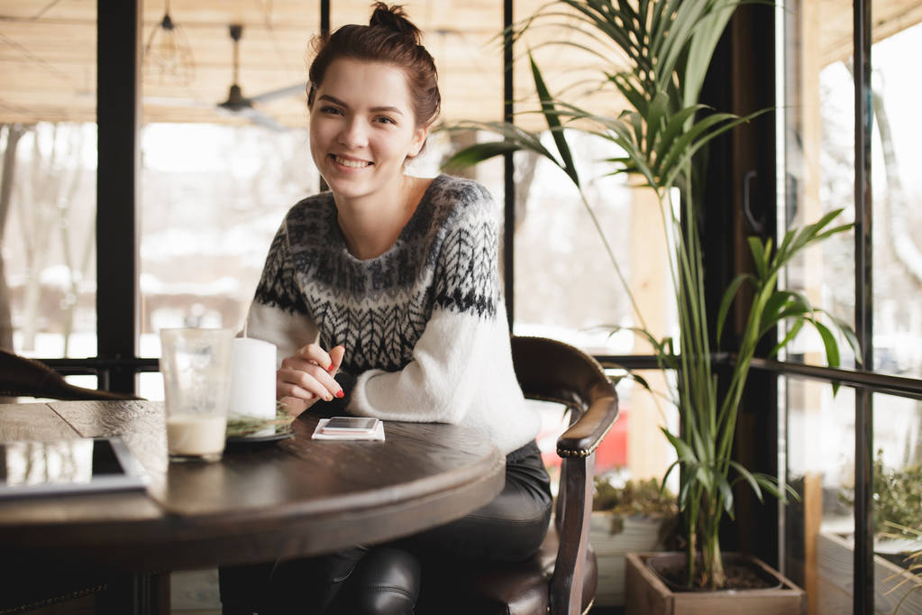 Moderni nainen tablet-tietokone ja älypuhelin kahvilassa hymyilee kameralle
 - Valokuva, kuva