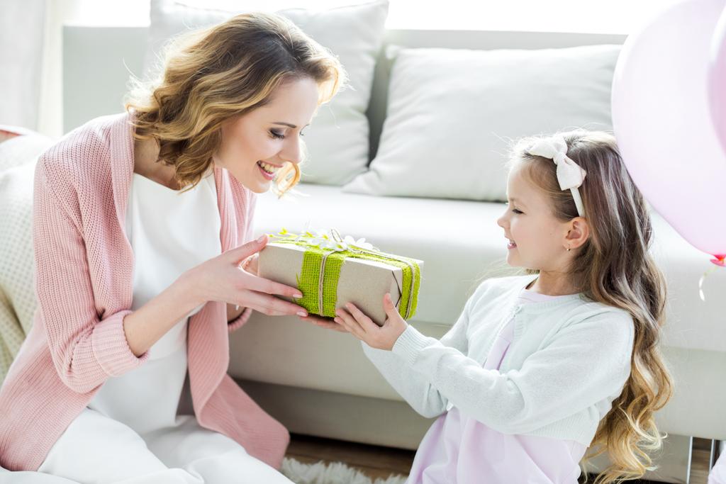 Girl presenting gift to mother  - Photo, Image
