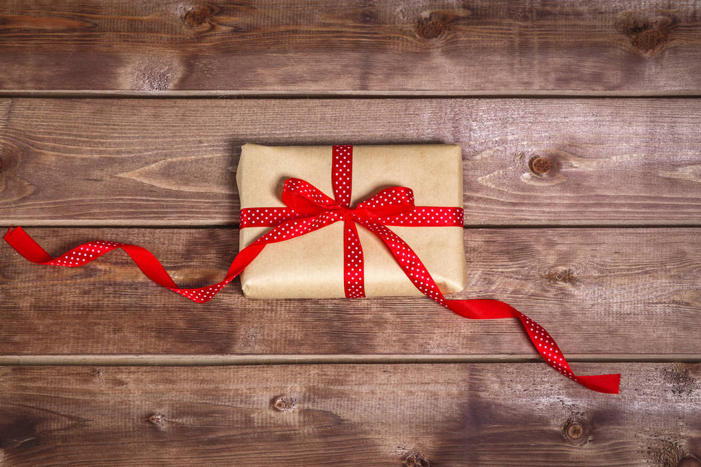 Confezione regalo vintage avvolto con fiocco a nastro rosso su sfondo in legno può essere utilizzato per la festa della mamma di San Valentino
  - Foto, immagini