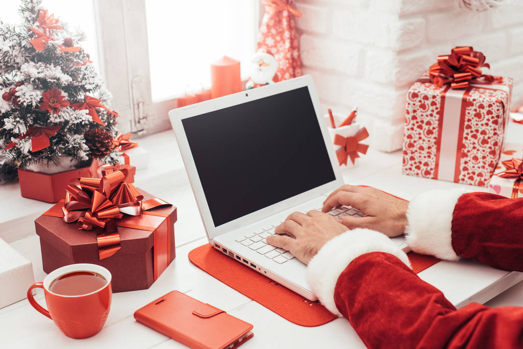 Santa conectando com um laptop
 - Foto, Imagem