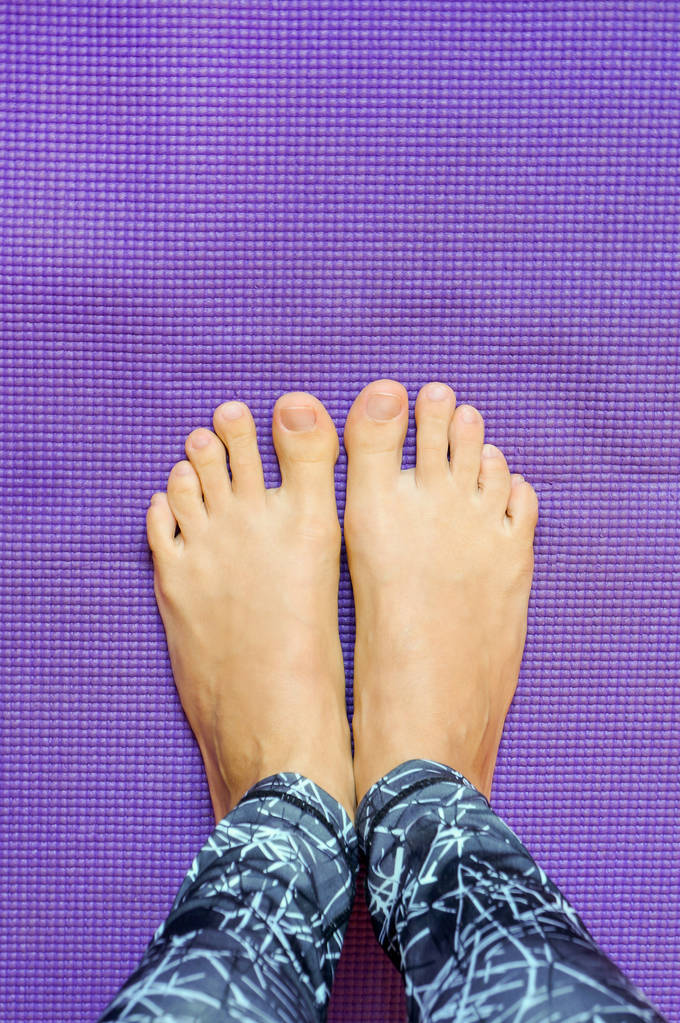 Patas de yoga sobre estera púrpura
 - Foto, Imagen