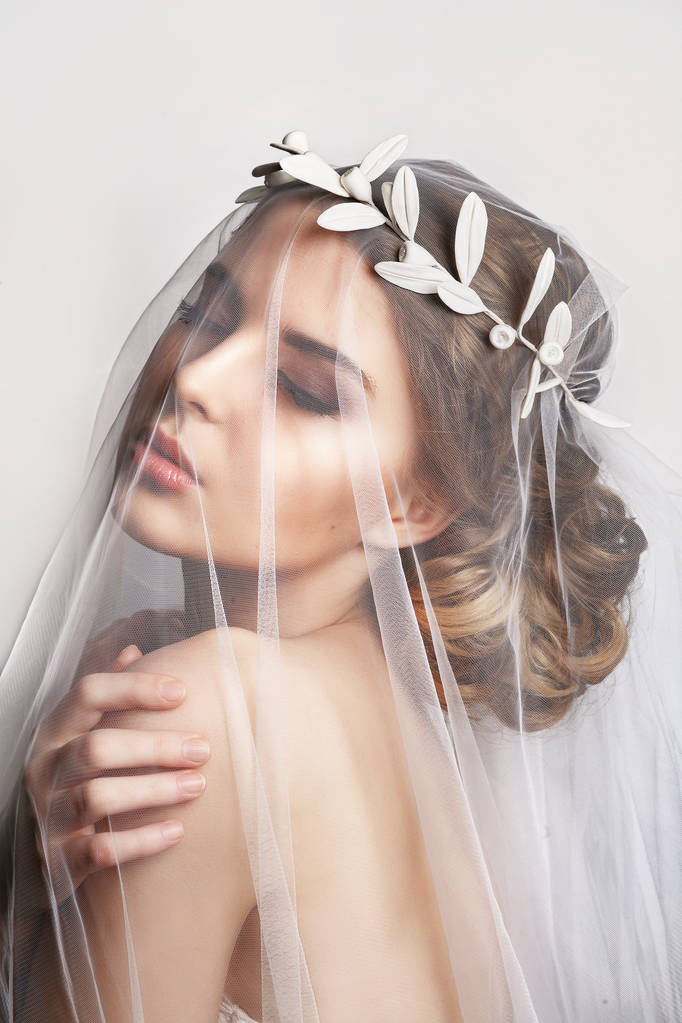 Beautiful bride with fashion wedding hairstyle - on white background.Closeup portrait of young gorgeous bride. Wedding. Studio shot.Beautiful bride portrait with veil over her face - Photo, Image