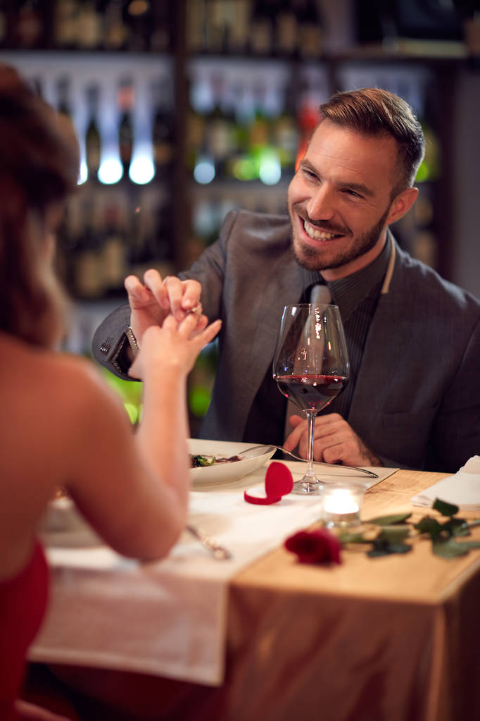 Mężczyzna zajmuje atrakcyjną kobietę w restauracji - Zdjęcie, obraz