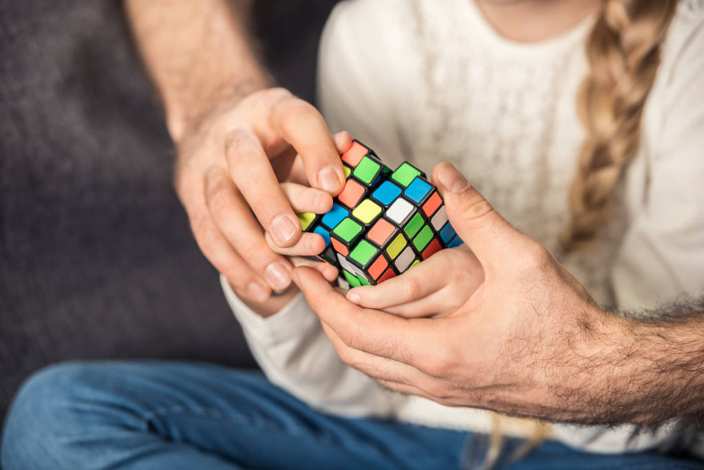 Vater und Tochter spielen mit Rubik 's Cube - Foto, Bild