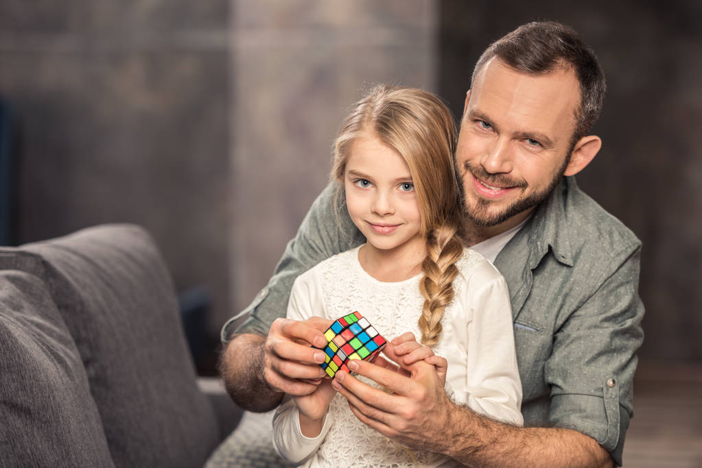 Father and daughter playing with rubik's cube - Photo, Image
