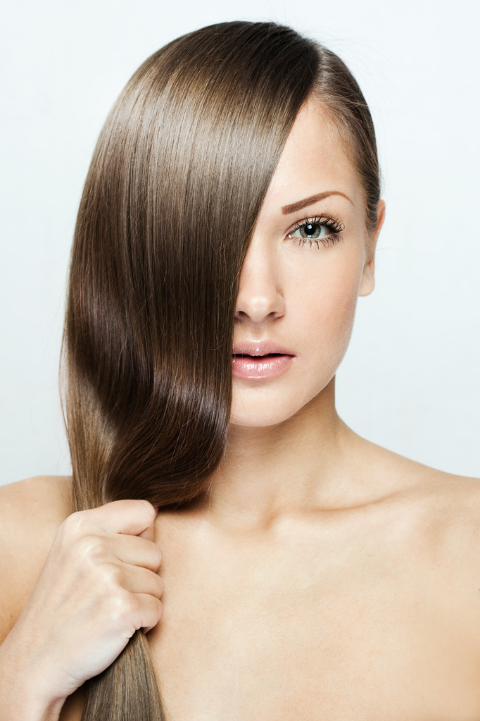 Joven mujer atractiva sosteniendo su cabello
 - Foto, imagen