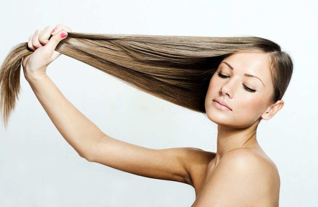 Giovane donna attraente tenendo i capelli
 - Foto, immagini