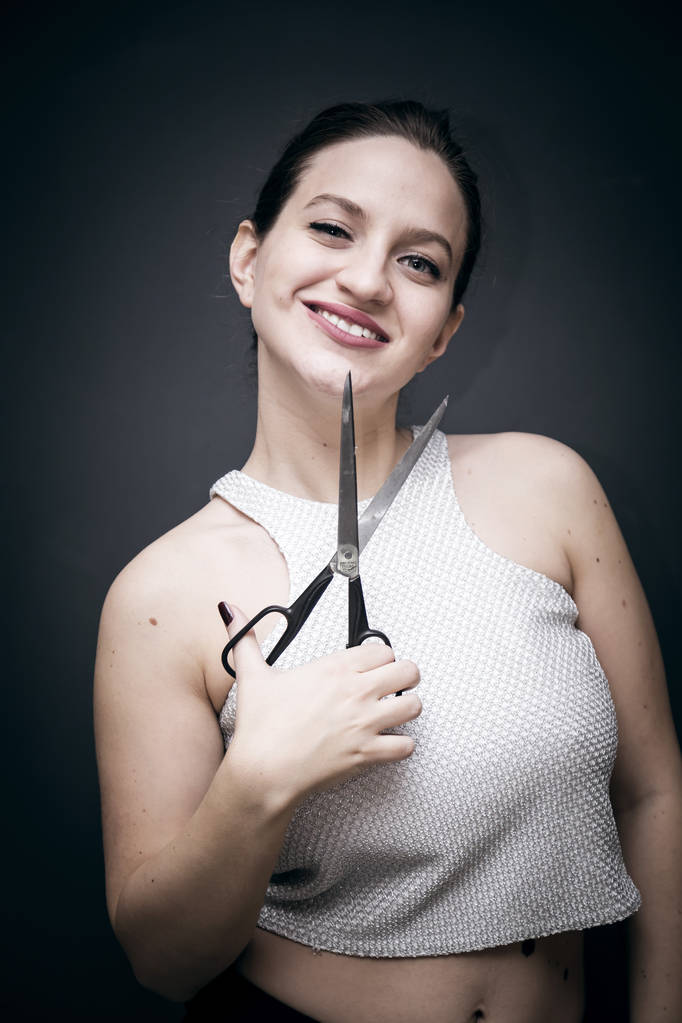 Young and beautiful girl holding a pair of scissors - Photo, Image