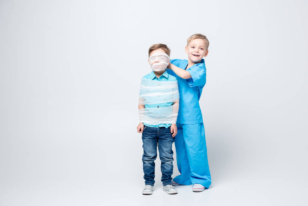 lapset leikkivät lääkäriä ja potilasta
 - Valokuva, kuva