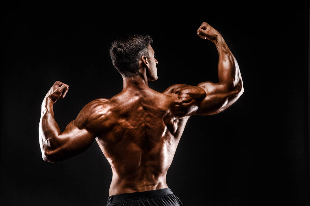 Vista posteriore dell'uomo irriconoscibile, muscoli forti in posa con le braccia alzate
 - Foto, immagini