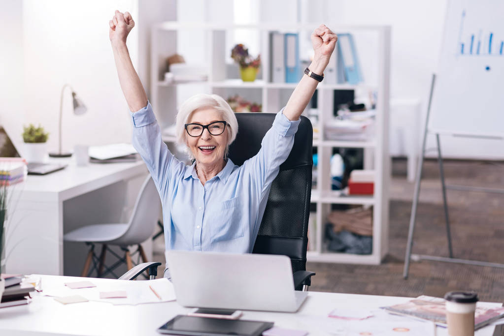 Divertente donna d'affari anziana che esprime gioia in ufficio
 - Foto, immagini